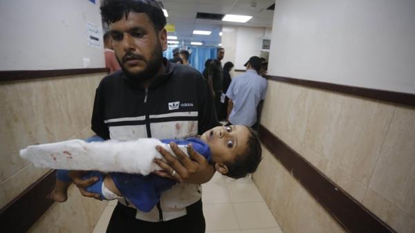 An injured child is brought to Al Asqa Martyr's Hospital in Deir al Balah